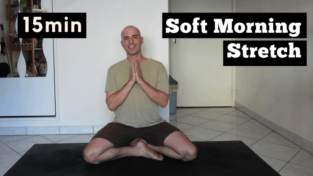 Smiling man sitting peacefully after a gentle morning yoga practice, feeling calm and refreshed after a 15-minute soft stretch routine.